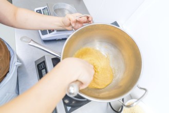 A person works with dough in a pan on a stove, Christmas baking, Haselstaller Hof, Wildberg,