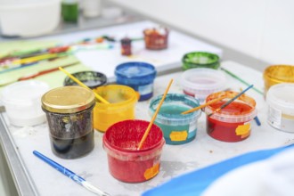 Colourful painting supplies on a table with coloured containers and brushes, Christmas baking,