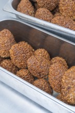 Brown chocolate chocolates with ground hazelnuts served in a metal container, Christmas baking,