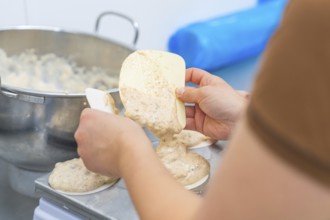 Two hands working with a dough and a silicone spatula on a kitchen table, Christmas baking,