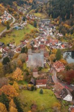 A medieval village surrounds a castle, all bathed in rich autumn colors, Berneck Castle,
