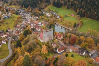 A castle and an idyllic village on a river surrounded by autumn trees, Berneck Castle, Altentsteig,