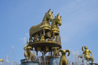 Close-up of golden horses and ram statues above a fountain under a blue sky, Colchis Fountain,