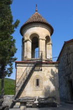 Round church tower with stone steps and red roof, immersed in quiet rural surroundings, Motsameta