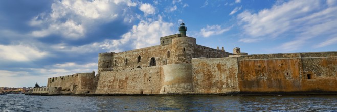 Syracuse, Ortigia island, mighty fortress overlooking the sea under a partly cloudy sky, Baroque