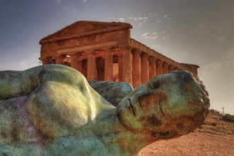 Bronze statue of fallen Icarus, Temple of Concordia, bronze statue in front of an ancient temple in