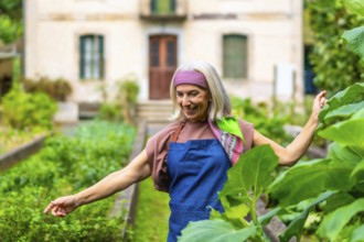 Senior woman with gray hair and colorful headband smiling while standing in her flourishing home