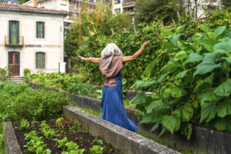 Senior woman with gray hair and scarf feeling freedom and happiness, walking with arms outstretched