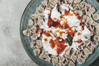 The dish features a generous serving of Turkish dumplings topped with velvety yogurt and a drizzle