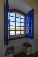 Colonial house in the city of Congonhas seen through the window of a historic Baroque church,