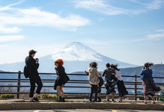 Tourists enjoy the view and take pictures, view of the snow-covered summit of Mount Fuji volcano in