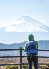 Tourist enjoying the view of the snow-covered summit of Mount Fuji volcano in spring, Owakudani,