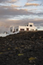 Typical white houses in the town of La Santa, at sunset, black volcanic rocks, Lanzarote, Canary