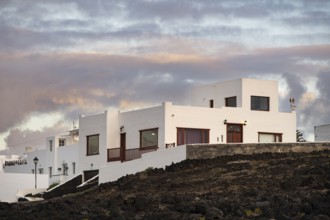 Typical white houses in the town of La Santa, at sunset, black volcanic rocks, Lanzarote, Canary