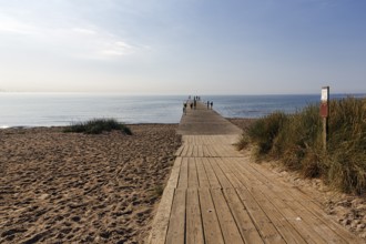 Wooden walkway on the beach, bathers on the horizon, summer in Ystad, Baltic Sea, Sweden