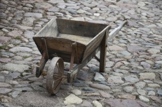Old-fashioned wheelbarrow on paving stones in Den gamle by, The old village, open air museum in