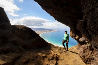 Tourist in the Cueva de las Cabras cave, young woman enjoying the view from the Risco de Famara