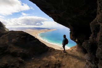 Tourist in the Cueva de las Cabras cave, old woman enjoying the view from the Risco de Famara