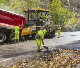 Asphalt road construction team of workers resurfacing tarmac in rural area, near Albarracin, Teruel