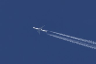 Boeing jet passenger aircraft of United airways airlines flying in a blue sky with contrails or