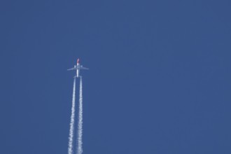 Boeing 737 jet passenger aircraft of Norwegian Air airlines flying in a blue sky with contrails or
