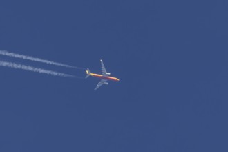 Boeing 767 jet cargo aircraft of DHL airlines flying in a blue sky with contrails or vapours trails
