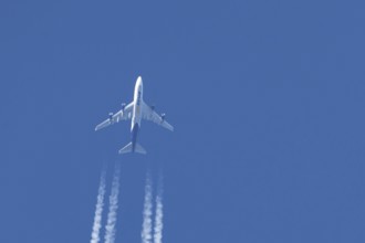 Boeing 747 jumbo jet cargo aircraft of Atlas air airlines flying in a blue sky with contrails or