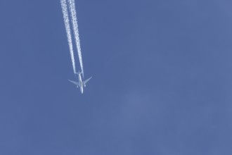 Boeing 777 jet passenger aircraft of Qatar airways airlines flying in a blue sky with contrails or