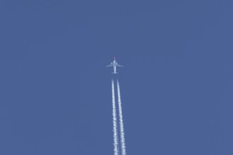 Boeing 737 jet passenger aircraft of Norwegian Air airlines flying in a blue sky with contrails or
