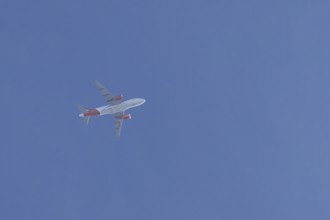 Airbus jet passenger aircraft of Easyjet airlines flying in a blue sky, England, United Kingdom