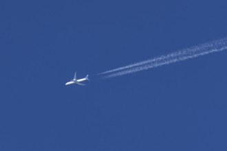 Boeing jet passenger aircraft of United airways airlines flying in a blue sky with contrails or