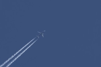 Boeing 737 jet passenger aircraft of Ryanair airlines flying in a blue sky with contrails or vapour
