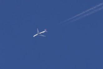 Boeing jet passenger aircraft of Delta airways airlines flying in a blue sky with contrails or
