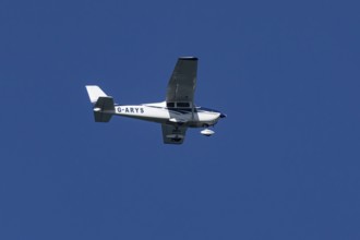 Cessna 172C Skyhawk light aircraft flying in a blue sky, England, United Kingdom