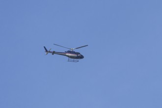 Airbus H125 helicopter flying in a blue sky, England, United Kingdom