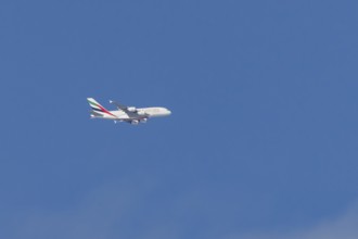 Airbus A380 jet passenger aircraft of Emirates airlines flying in a blue sky, England, United