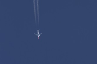 Boeing 737 jet passenger aircraft of Norwegian Air airlines flying in a blue sky with contrails or