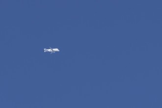 Airbus A330-743L Beluga XL cargo jet aircraft flying in a blue sky with white clouds, England,