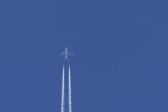 Airbus jet passenger aircraft of Kuwait airways flying in a blue sky with contrails or vapour