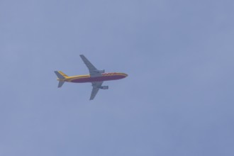 Boeing 767 jet cargo aircraft of DHL airlines flying in a blue sky, England, United Kingdom