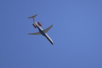 Embraer ERJ-145 jet passenger aircraft of Loganair airlines flying in a blue sky, England, United