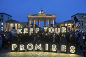 Participants hold glowing letters with the words Keep Your Promises at the international climate