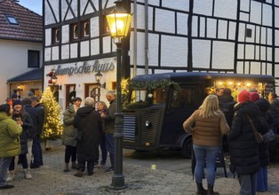 People at the decorated half-timbered house of the restaurant et Kemp'sche huus in the evening, Old