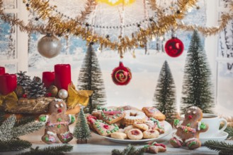 Christmas table with cookies, balls and decoration in front of snowy landscape