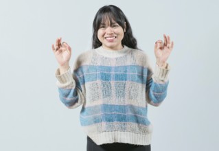 Smiling female interpreter gesturing OK in sign language. Smiling asian girl gesturing okay in