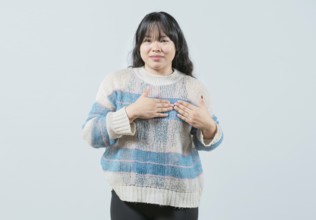 Asian girl gesturing GRATITUDE in sign language. Young woman making gesture GRATEFUL in sign
