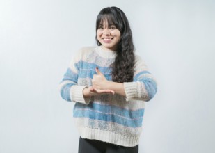Asian girl gesturing help with hands in nonverbal language. Smiling woman showing help gesture with