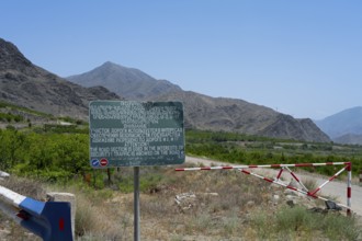 A sign and a barrier are on a road with safety warnings, sign on the M17 road that runs along the