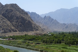 A green landscape with a river and mountains in the background, view of Iran, Aras River near