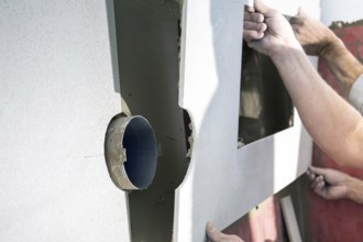 Tilers install wall tiles in a new bathroom